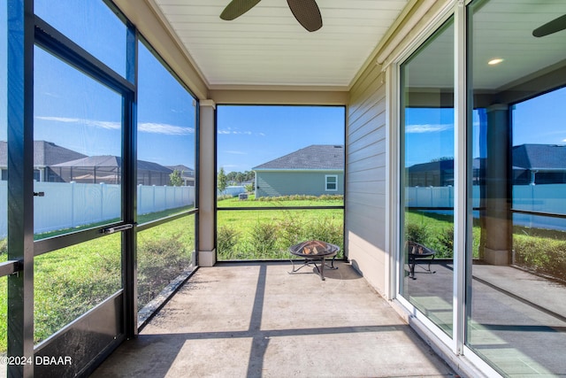 sunroom / solarium featuring a residential view and a ceiling fan