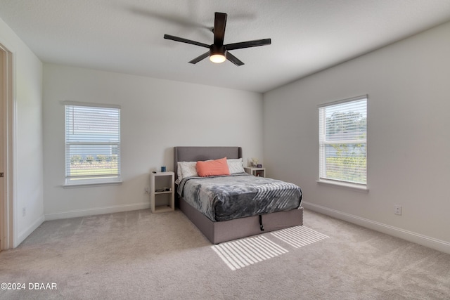 bedroom with baseboards, a ceiling fan, and light colored carpet