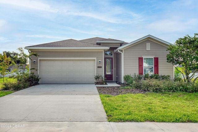 view of front of house featuring a garage, concrete driveway, and a front lawn