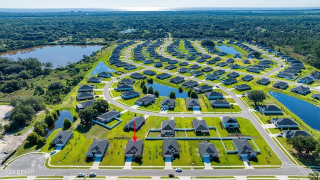 birds eye view of property featuring a forest view, a water view, and a residential view