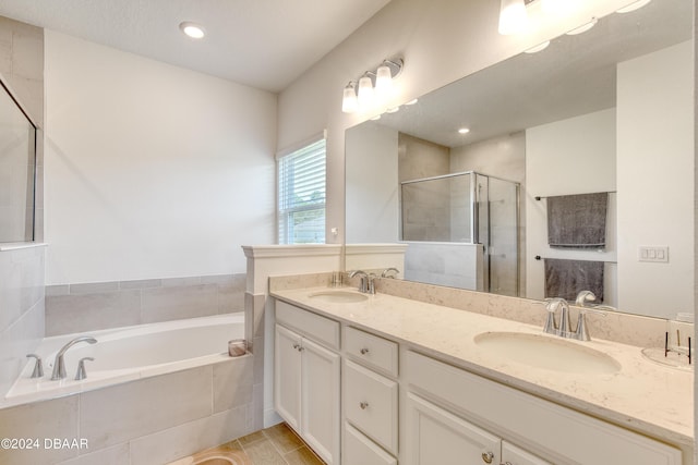 bathroom with double vanity, a sink, a shower stall, and a bath