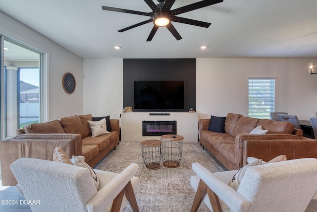 living room with ceiling fan, a textured ceiling, and recessed lighting