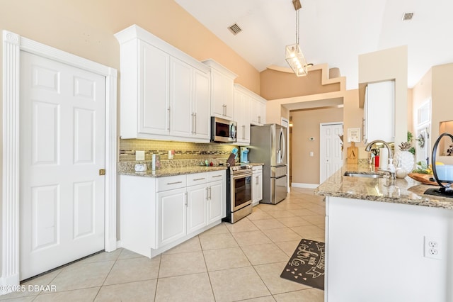 1405 Florida Moss Ln, Port Orange, FL 32128 - kitchen with stainless steel appliances, backsplash, white cabinetry, light tile patterned floors, and light stone countertops