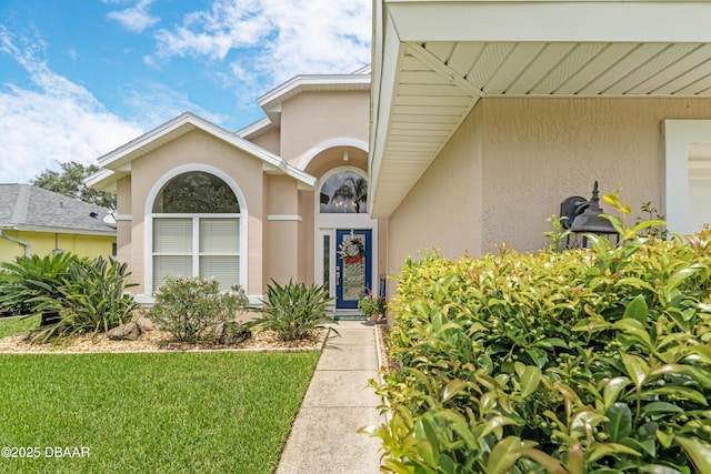 1405 Florida Moss Ln, Port Orange, FL 32128 - view of exterior entry with stucco siding and a lawn