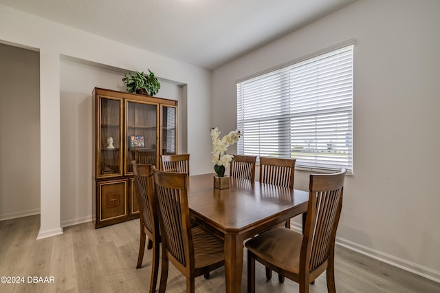 dining space with decorative columns and light hardwood / wood-style floors