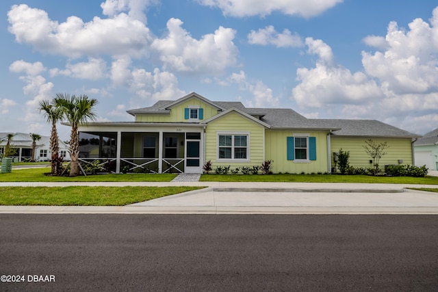 view of front of house with a front lawn and a sunroom