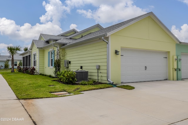 view of property exterior featuring a garage, central AC unit, and a yard