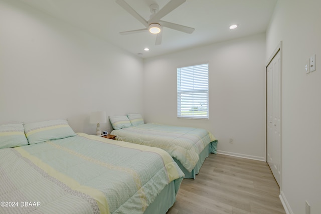 bedroom with a closet, ceiling fan, and light hardwood / wood-style flooring