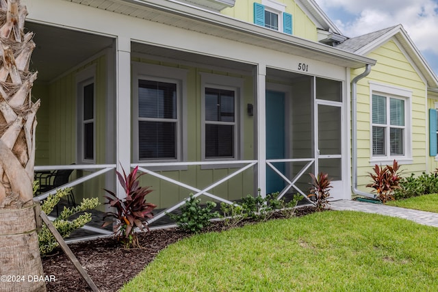 view of exterior entry featuring a yard