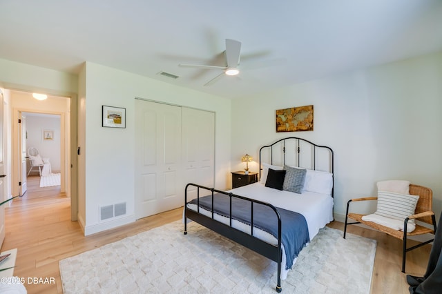 bedroom with baseboards, visible vents, a closet, and light wood-type flooring