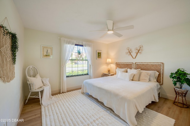 bedroom featuring ceiling fan, baseboards, and light wood-style floors