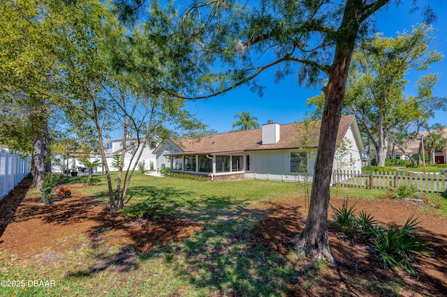 view of yard featuring a fenced backyard and a sunroom