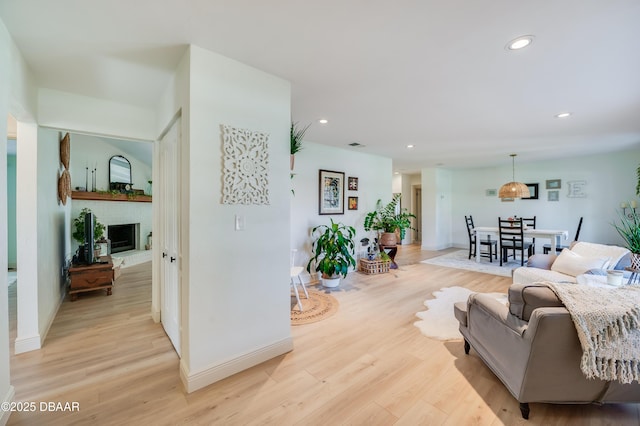 living area featuring visible vents, recessed lighting, a fireplace, and light wood-type flooring