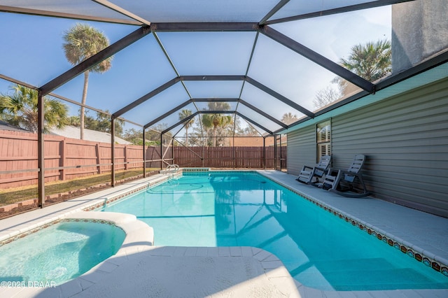 view of pool with glass enclosure and a patio area