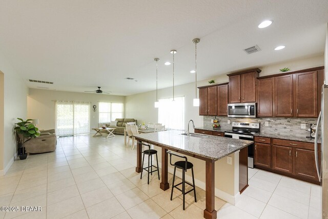 5567 Estero Loop, Port Orange, FL 32128 - kitchen with visible vents, a ceiling fan, open floor plan, a sink, and stainless steel appliances