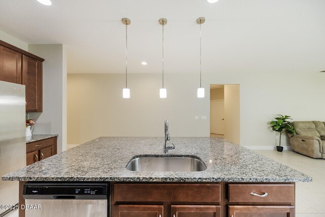 5567 Estero Loop, Port Orange, FL 32128 - kitchen with appliances with stainless steel finishes, light stone counters, a sink, light tile patterned floors, and a center island with sink