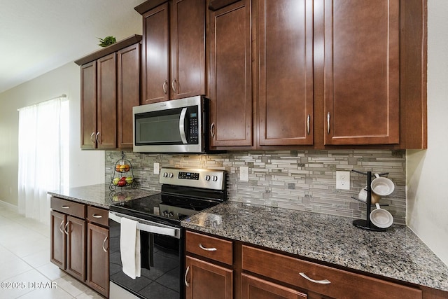 5567 Estero Loop, Port Orange, FL 32128 - kitchen featuring light tile patterned floors, dark stone counters, decorative backsplash, and stainless steel appliances