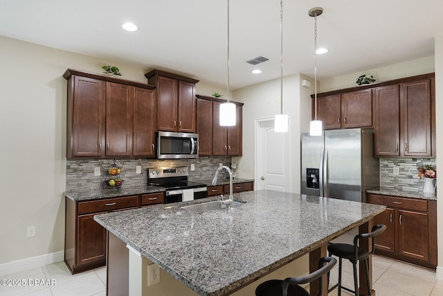 5567 Estero Loop, Port Orange, FL 32128 - kitchen featuring a sink, appliances with stainless steel finishes, a breakfast bar area, and light tile patterned flooring