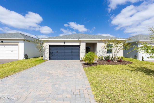 5567 Estero Loop, Port Orange, FL 32128 - view of front of home featuring decorative driveway, a garage, a front lawn, and stucco siding