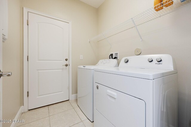 5567 Estero Loop, Port Orange, FL 32128 - washroom featuring baseboards, laundry area, light tile patterned flooring, and washing machine and clothes dryer