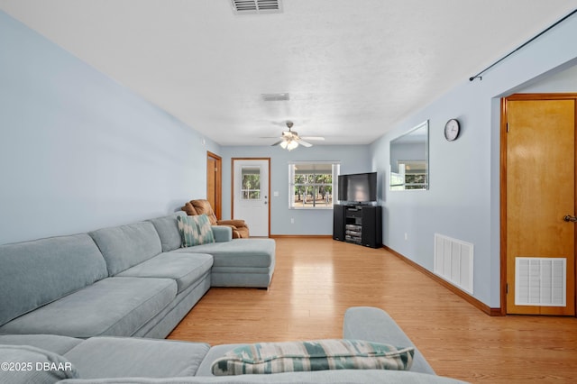 living room featuring ceiling fan and light hardwood / wood-style floors