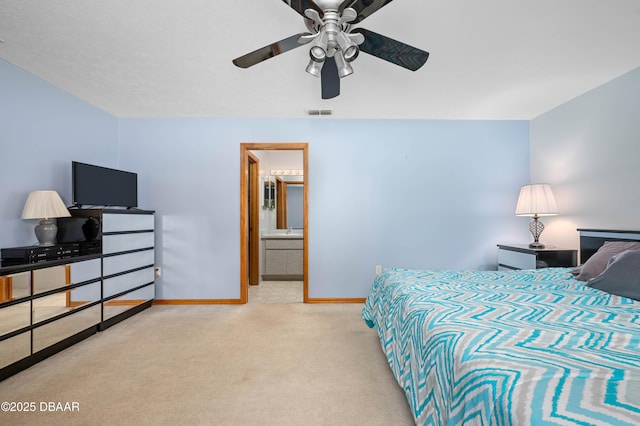 carpeted bedroom with ensuite bathroom and ceiling fan