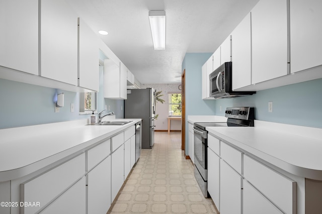 kitchen featuring white cabinetry, appliances with stainless steel finishes, and sink