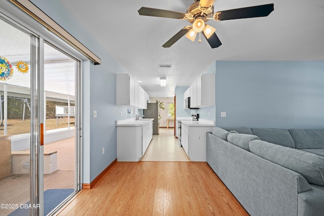 living room with sink, ceiling fan, and light hardwood / wood-style flooring