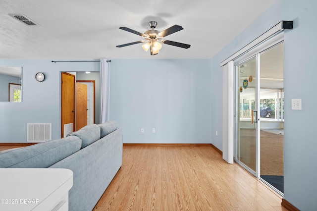 living room featuring light hardwood / wood-style floors and ceiling fan