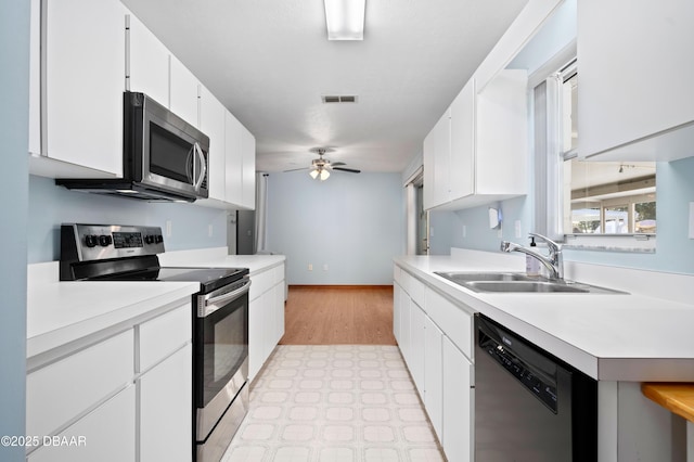 kitchen featuring ceiling fan, appliances with stainless steel finishes, sink, and white cabinets