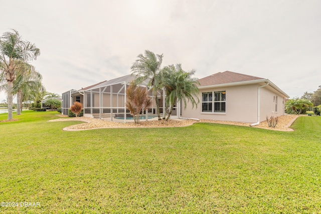 back of property with a yard and a lanai