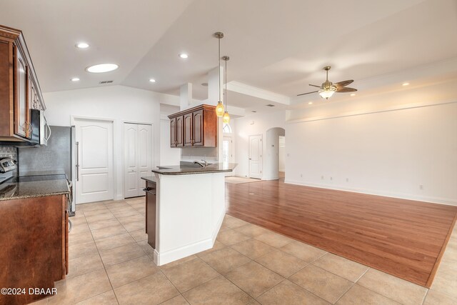 kitchen with kitchen peninsula, ceiling fan, light tile patterned floors, and pendant lighting