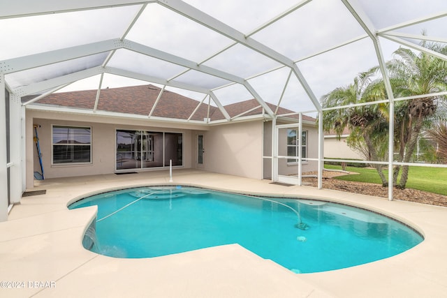 view of swimming pool with glass enclosure and a patio area