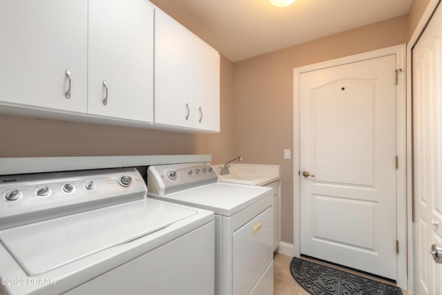 washroom featuring washer and dryer, light tile patterned floors, cabinets, and sink