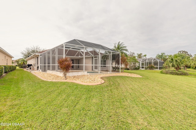 rear view of property with a lanai and a lawn