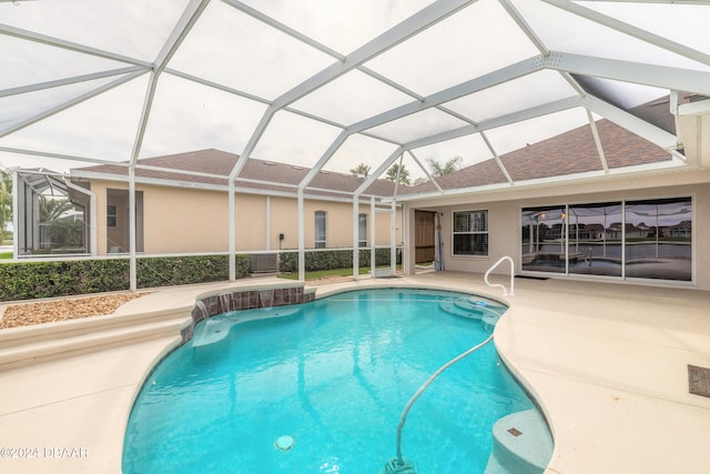 view of swimming pool featuring glass enclosure and a patio area