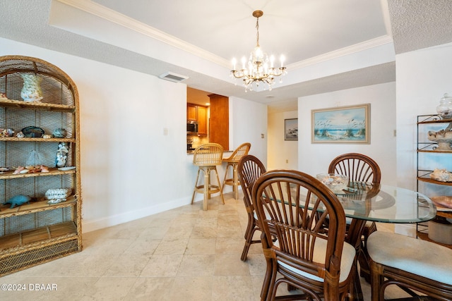 dining area with ornamental molding, a textured ceiling, a tray ceiling, and a chandelier