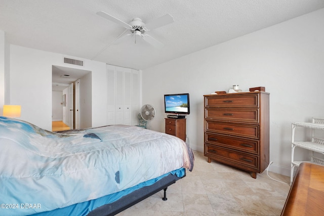 bedroom with a textured ceiling, a closet, and ceiling fan