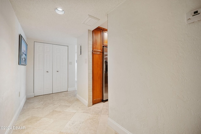 hallway with a textured ceiling