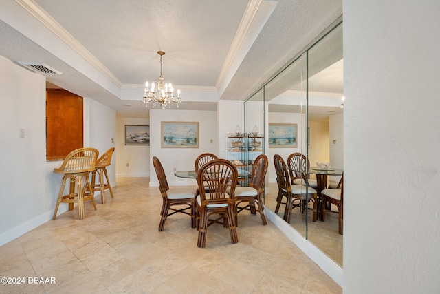 dining area featuring a chandelier, a textured ceiling, a tray ceiling, and ornamental molding