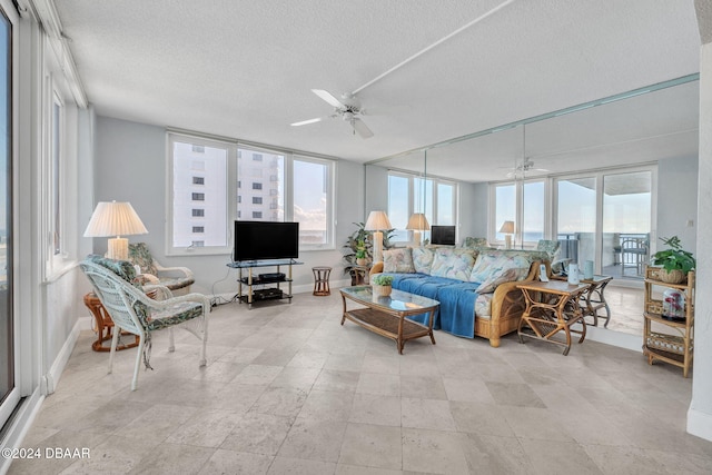 living room with ceiling fan and a textured ceiling