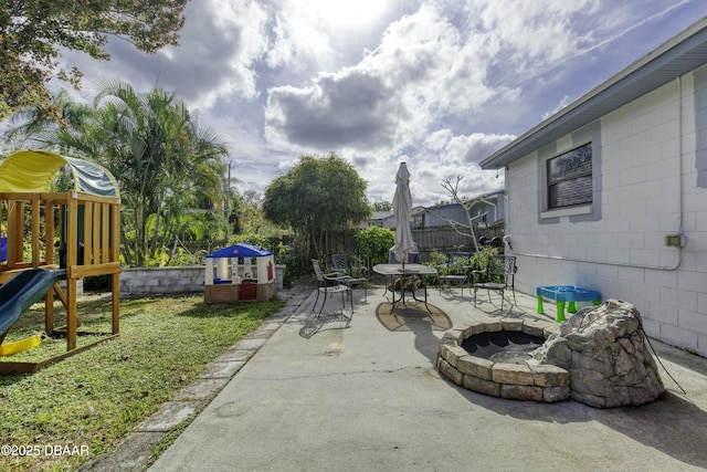 view of patio with a fire pit and a playground