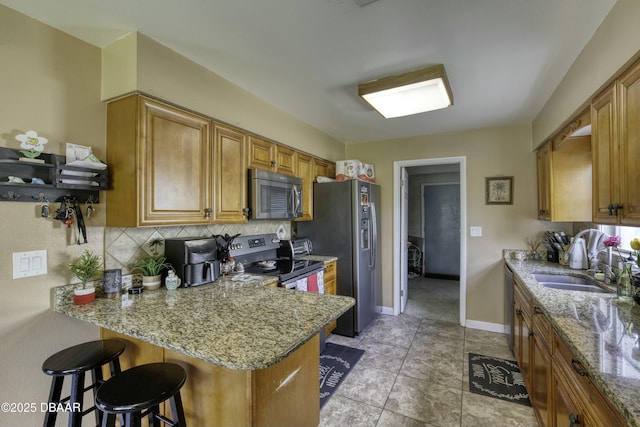 kitchen with sink, decorative backsplash, appliances with stainless steel finishes, a kitchen bar, and kitchen peninsula