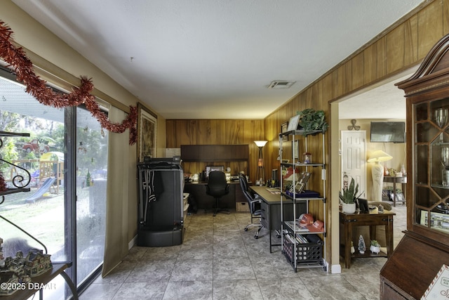 kitchen with tile patterned floors and wood walls