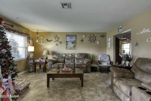 living room with tile patterned floors, a textured ceiling, and a notable chandelier