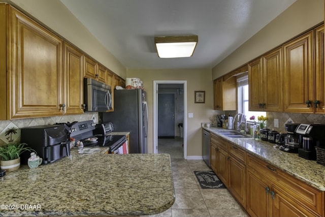 kitchen featuring sink, decorative backsplash, light stone countertops, appliances with stainless steel finishes, and light tile patterned flooring