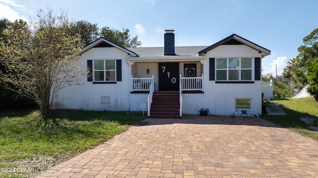 view of front of house with a porch and a front yard