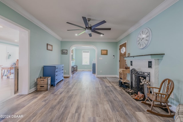 living room featuring ceiling fan, light hardwood / wood-style flooring, and crown molding