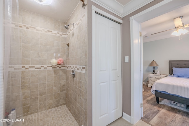 bathroom featuring crown molding, wood-type flooring, ceiling fan, and a tile shower