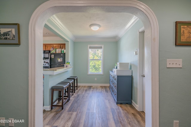 laundry room featuring hardwood / wood-style flooring and ornamental molding